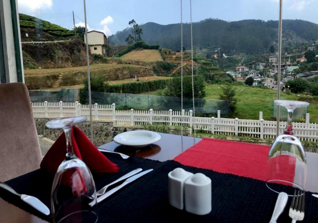 a dining table with a view of a mountain at The Blackpool Resort & Spa in Nuwara Eliya