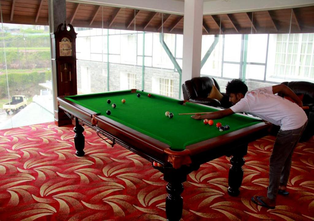 two people playing pool on a pool table at The Blackpool Resort & Spa in Nuwara Eliya