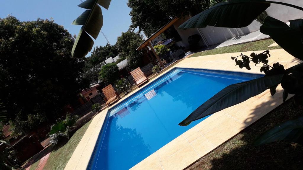 ein blauer Pool an der Seite eines Hauses in der Unterkunft Departamento Iguazú Cataratas in Puerto Iguazú