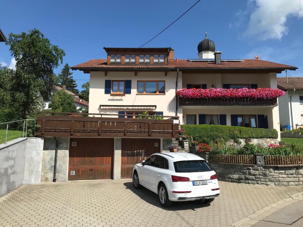 um carro branco estacionado em frente a uma casa em Ferienwohnung Grüntenblick em Rettenberg