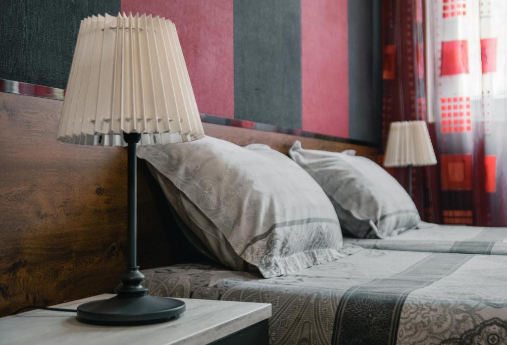 a lamp sitting on a table next to a bed at Sofia Central Hotel Apartments in Sofia