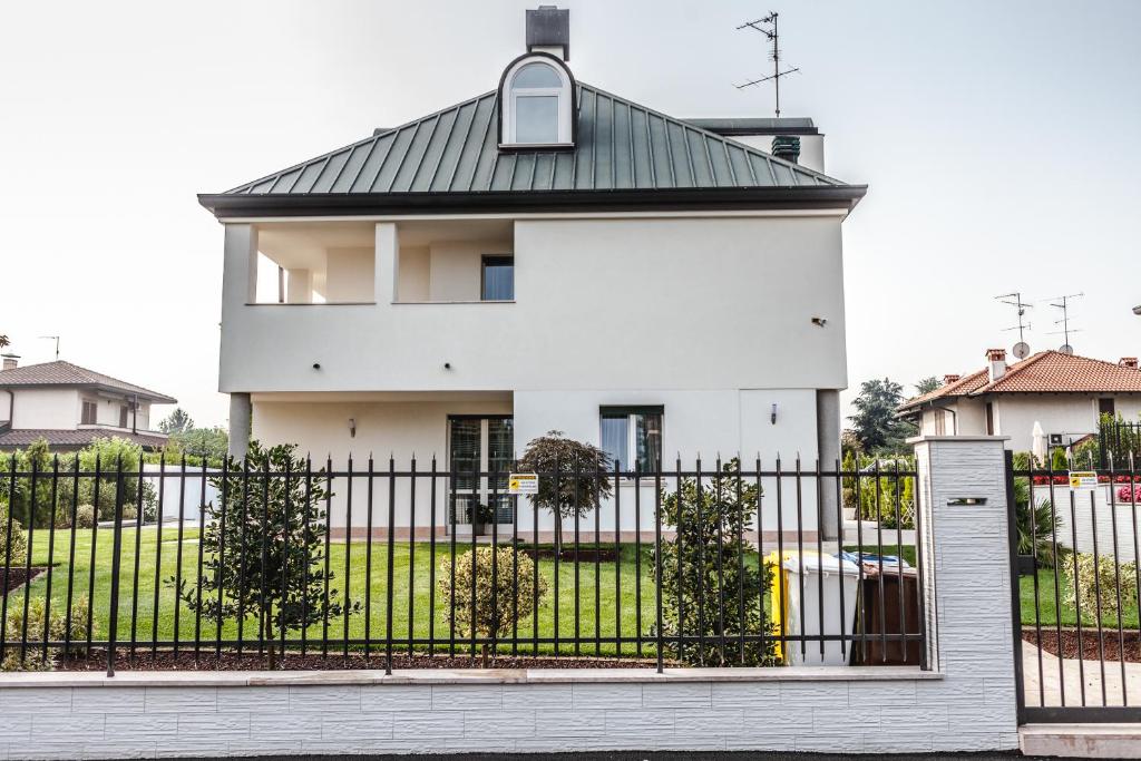 a white house with a black fence at B&B LUXURY ITALIAN HOUSE in Rho