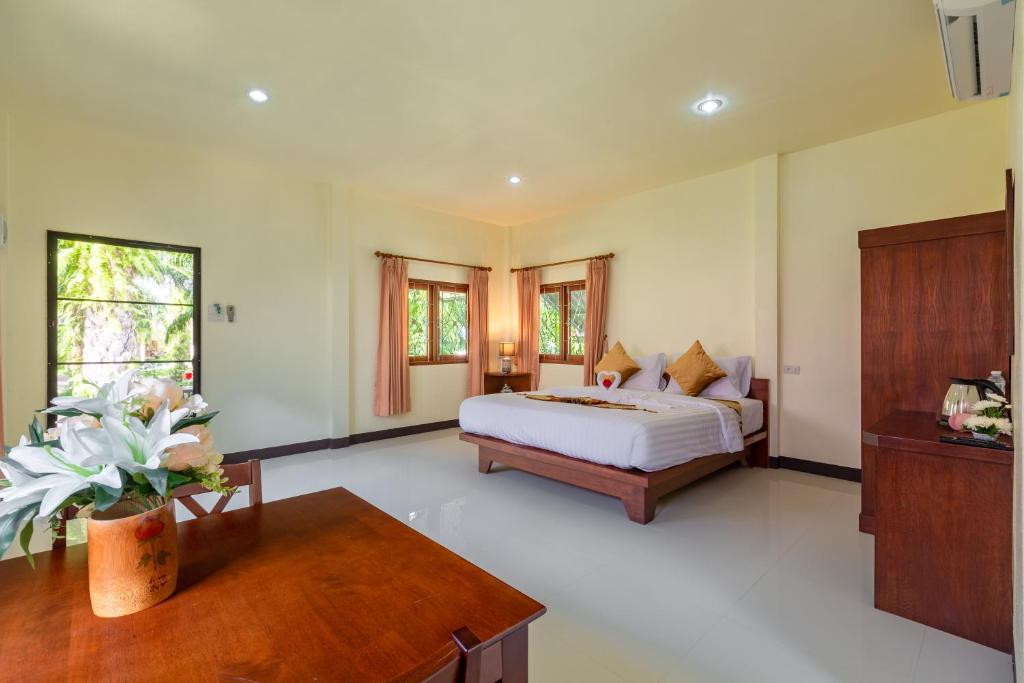 a bedroom with a bed and a couch and a table at Green Garden House in Ao Nam Mao