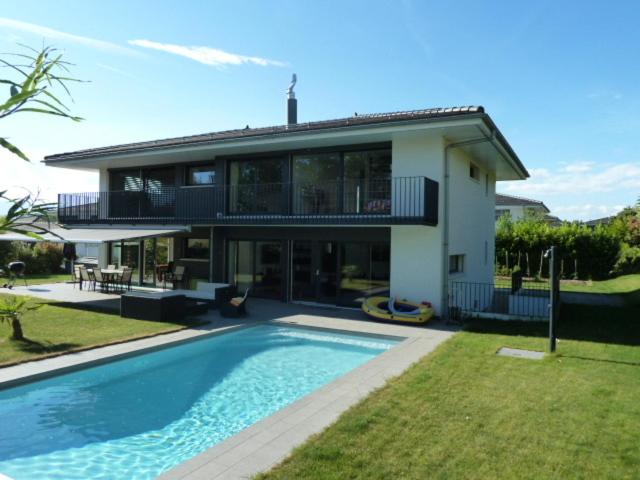 a house with a swimming pool in front of it at Montaney Guests House - EPFL in Ecublens