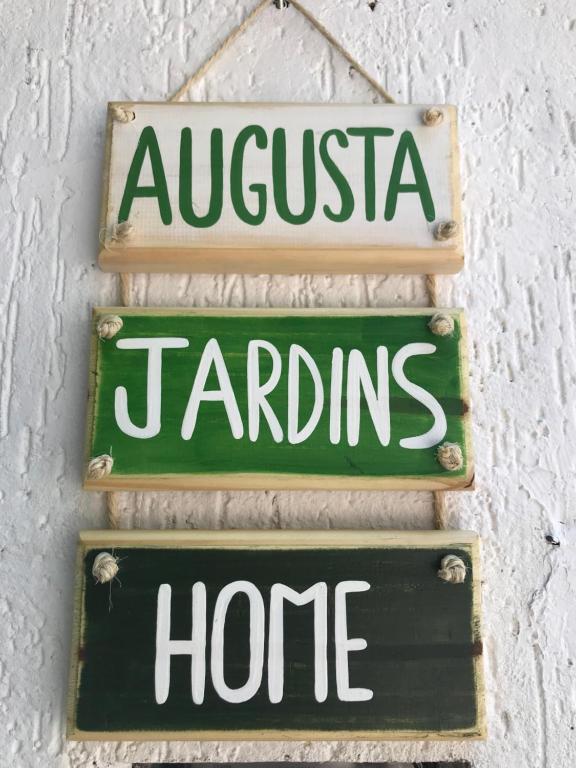 dois sinais pendurados numa parede com as palavras argentina e tardinas em Augusta Jardins Home em São Paulo