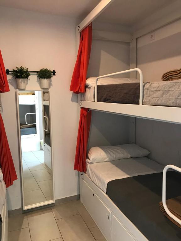 a room with two bunk beds and a mirror at Hostelscat in Barcelona