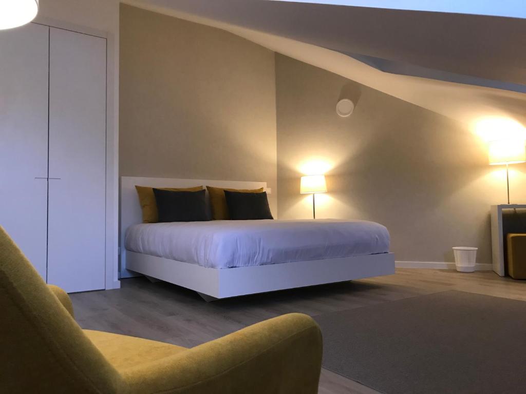 1 dormitorio con 1 cama con 2 lámparas y 1 silla en Lisbon10 en Lisboa