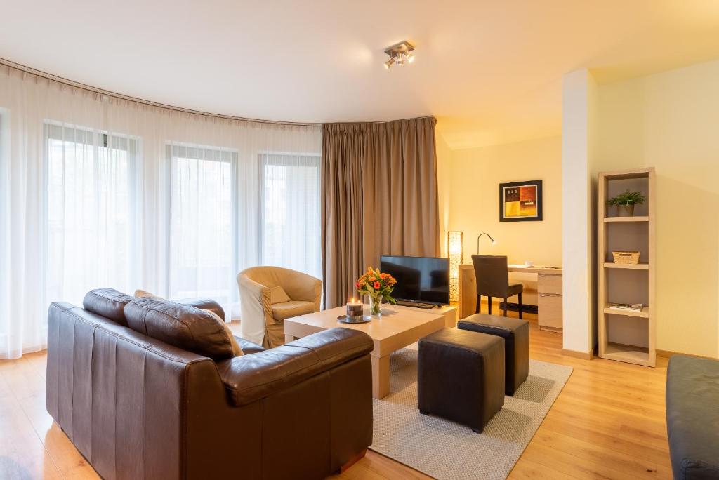 ein Wohnzimmer mit einem Sofa und einem Tisch in der Unterkunft EU Parliament Terrace Residence in Brüssel