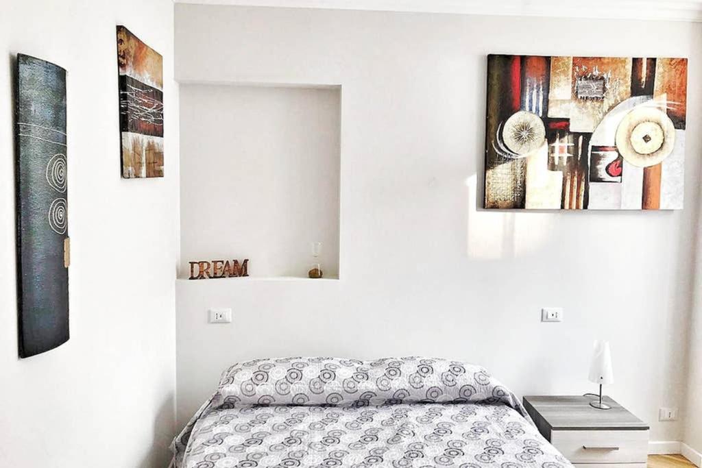 1 dormitorio con 1 cama y pinturas en la pared en Trilocale Gianluca, en San Remo