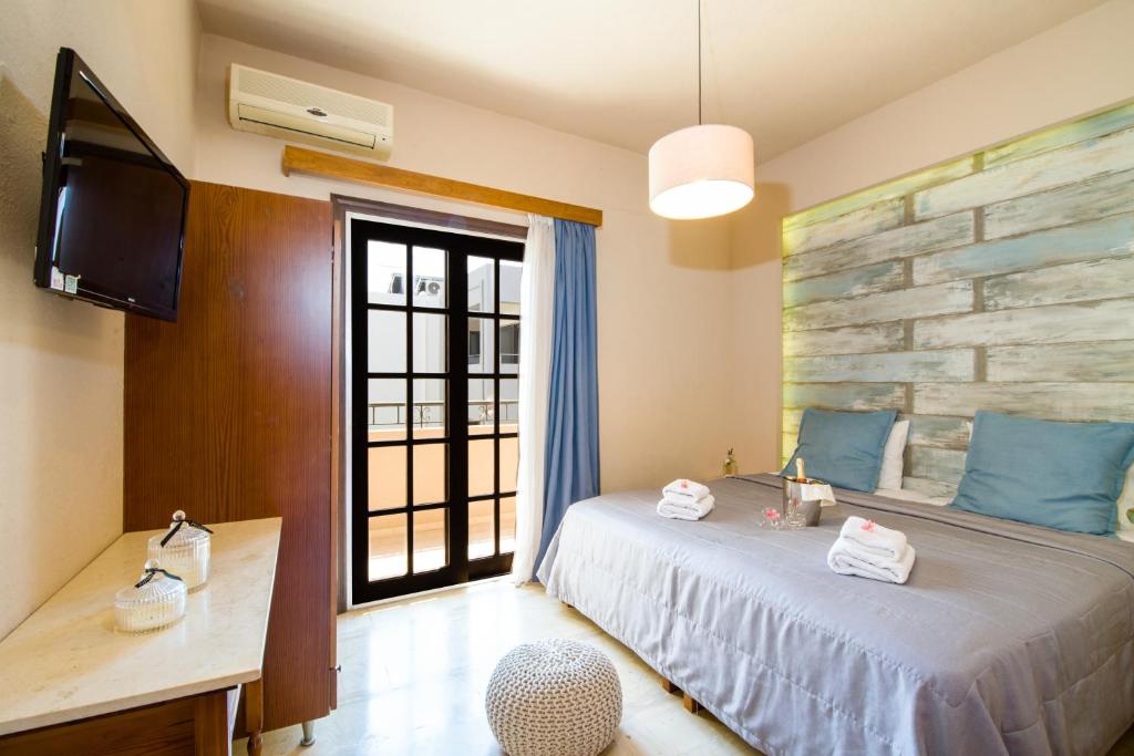 Schlafzimmer mit einem Bett und einem Flachbild-TV in der Unterkunft Evangelos Apartments in Platanias