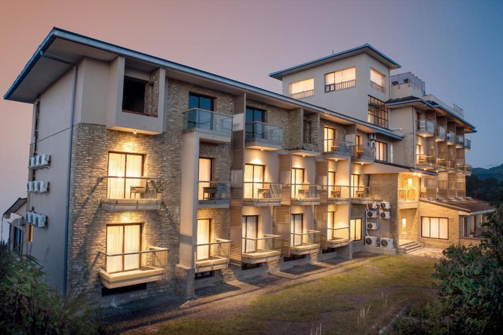an exterior view of a building with lights on at Sarangkot Mountain Lodge in Pokhara