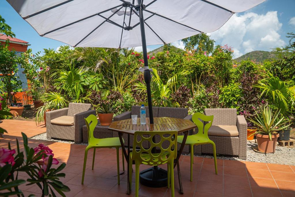 a table and chairs with an umbrella on a patio at Papaya Inn in Oranjestad