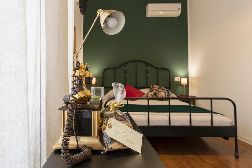 1 dormitorio con 1 cama con lámpara y mesa en Villa Noemi Bed&Breakfast en Pisa