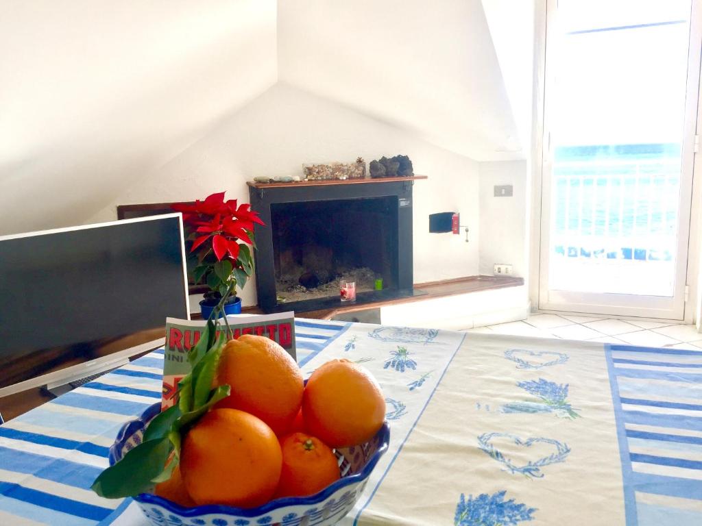 a bowl of oranges on a table with a fireplace at One bedroom appartement at Mascali 10 m away from the beach with sea view furnished terrace and wifi in Mascali