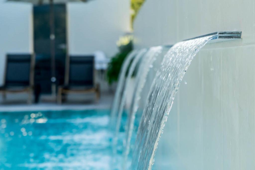 a water fountain in a swimming pool at Zante Flower Studios & Apartments in Alikanas
