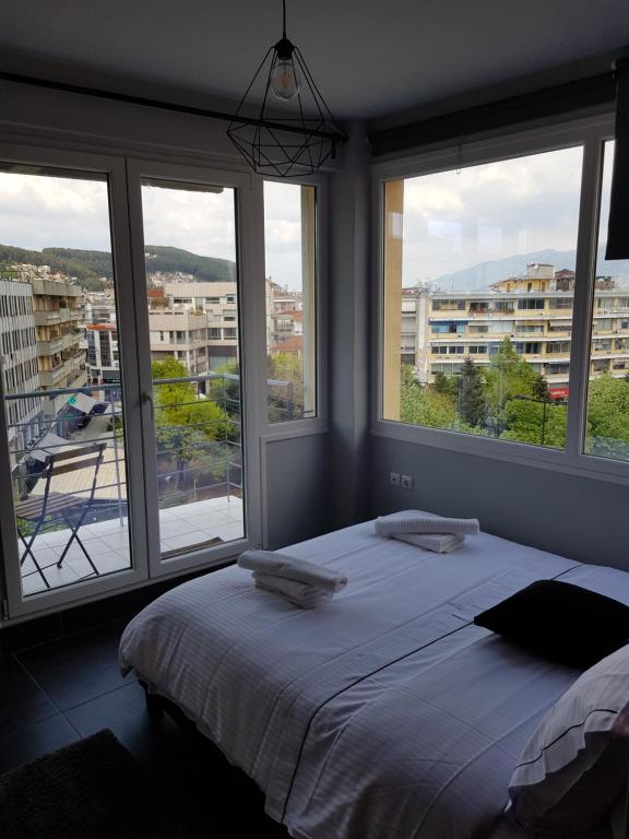 Schlafzimmer mit einem Bett und Fenstern mit Aussicht in der Unterkunft City Life Apartments #1 in Ioannina