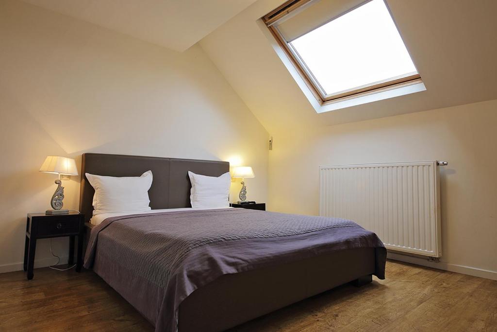 um quarto com uma cama grande e uma clarabóia em B&B Le Lys d'or em Bruxelas