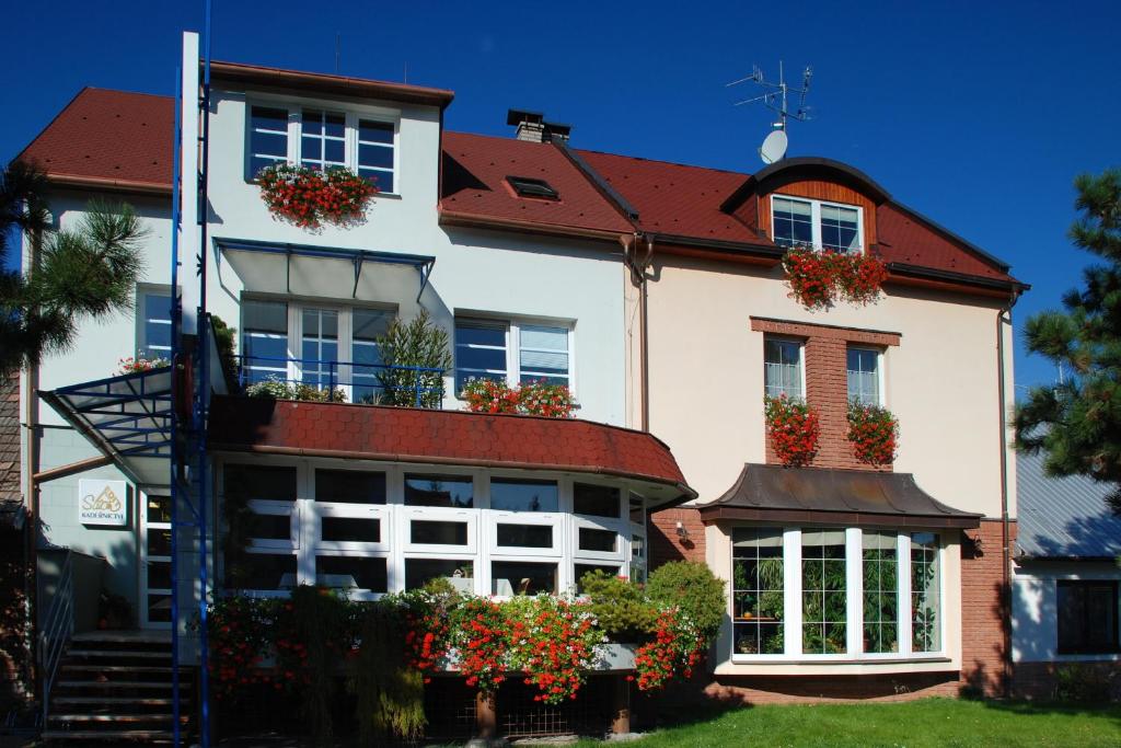 a house with flower boxes on the front of it at Penzion Rondo in Bystřice pod Hostýnem