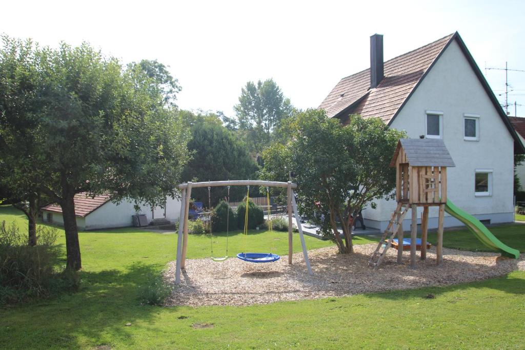 a playground in a yard with a swing at Ferienhaus an der Iller in Aitrach