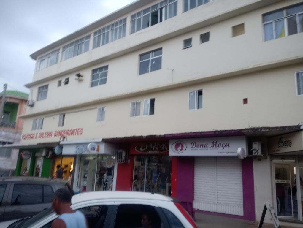 a building on a street with cars parked in front at Pousada bandeirantes in Ilhéus