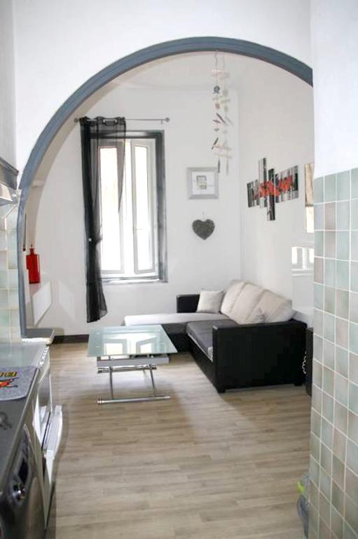 un salon avec un canapé noir et une table dans l'établissement Appartement lumineux à La Ciotat, 50 m², avec vue sur la ville, à La Ciotat