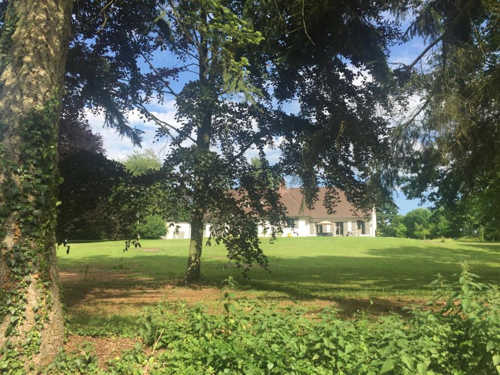 a house in the middle of a field with trees at Domaine de La Charmille in Ermenonville