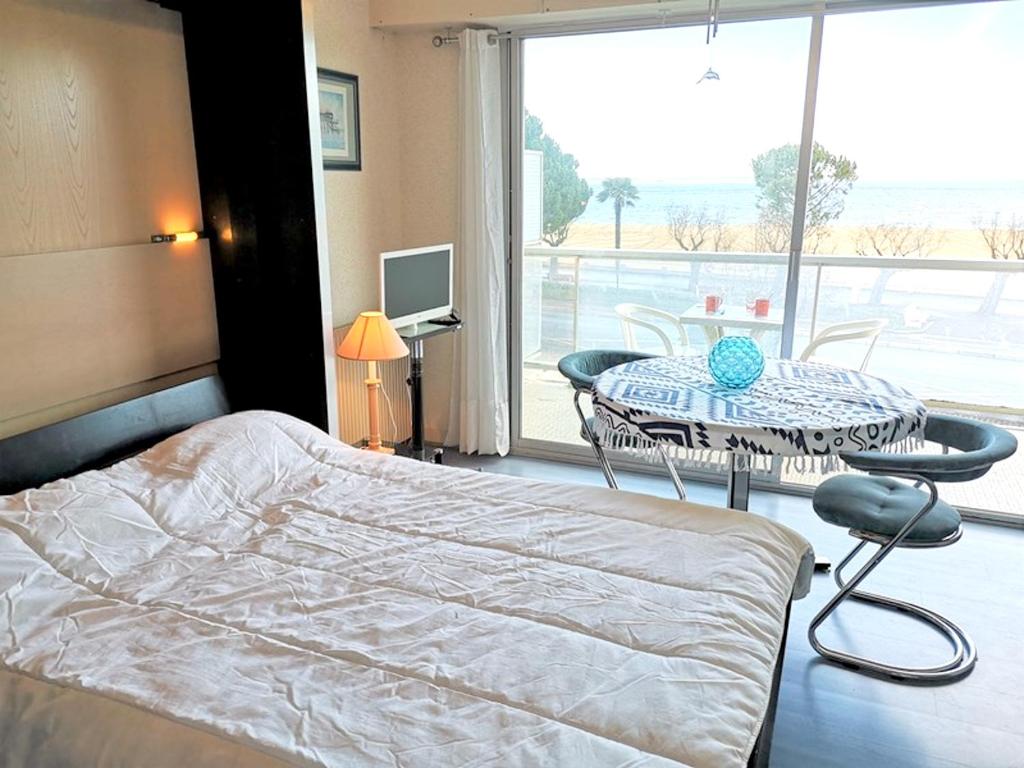 une chambre avec un lit, une table et une fenêtre dans l'établissement Charmant studio face à la mer à Arcachon 27 m² avec balcon superbe, à Arcachon