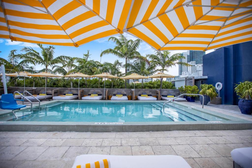 ein Swimmingpool mit Sonnenschirmen auf einem Hotel in der Unterkunft Catalina Hotel & Beach Club in Miami Beach