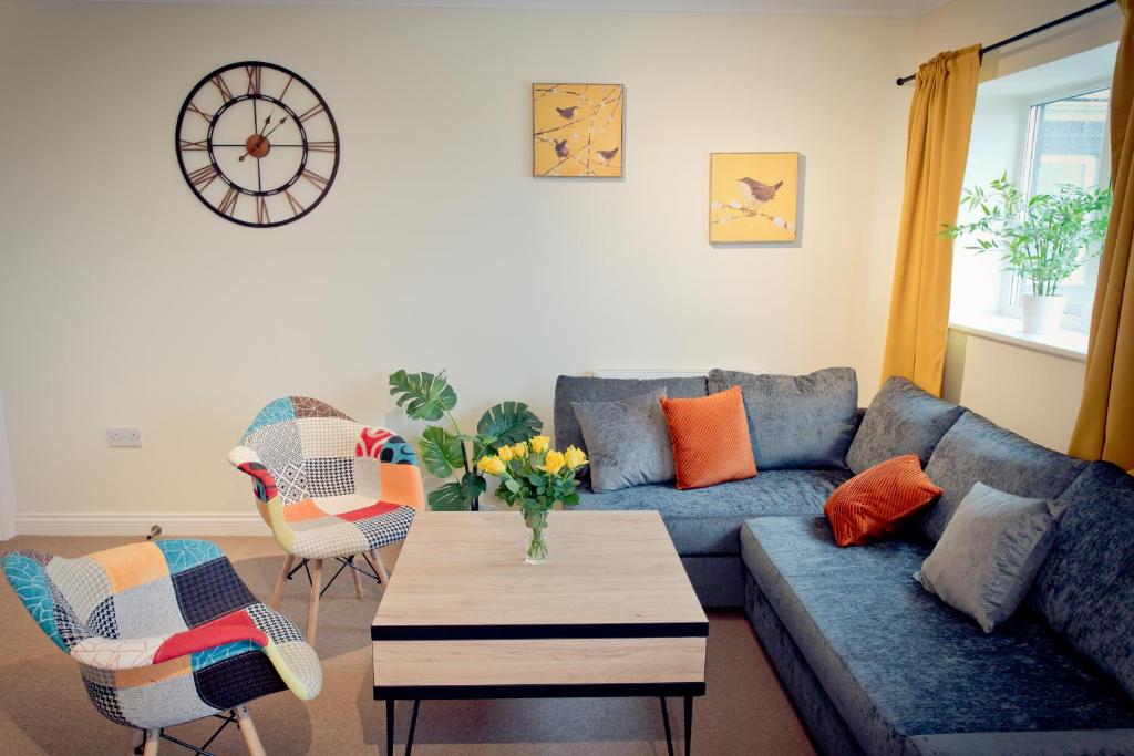 Top View 2 Bedroom Apartments Plymouth في بلايموث: غرفة معيشة مع أريكة زرقاء وطاولة