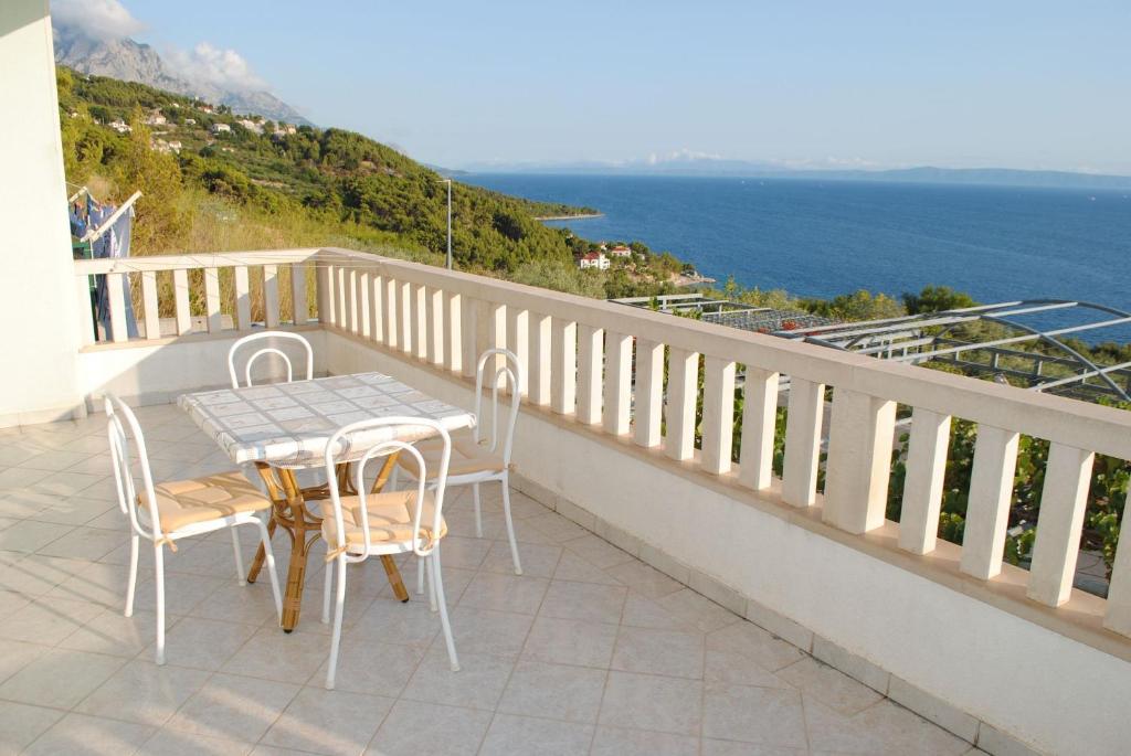 uma mesa e cadeiras numa varanda com vista para o oceano em Apartments Marko - amazing sea view em Brela
