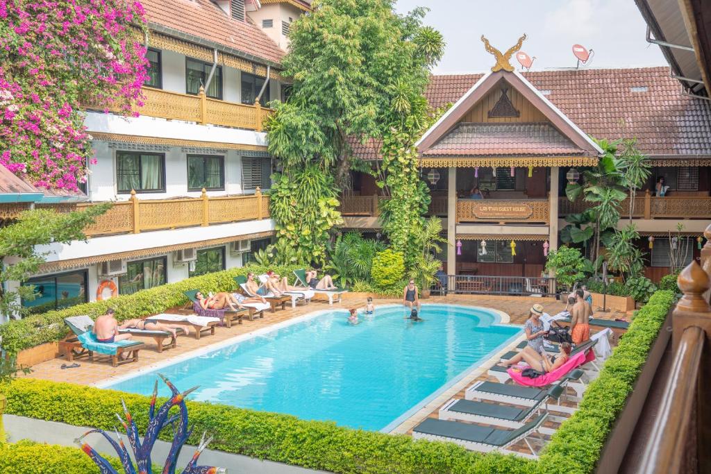 a group of people sitting around a pool at a hotel at Lai Thai Guest House in Chiang Mai