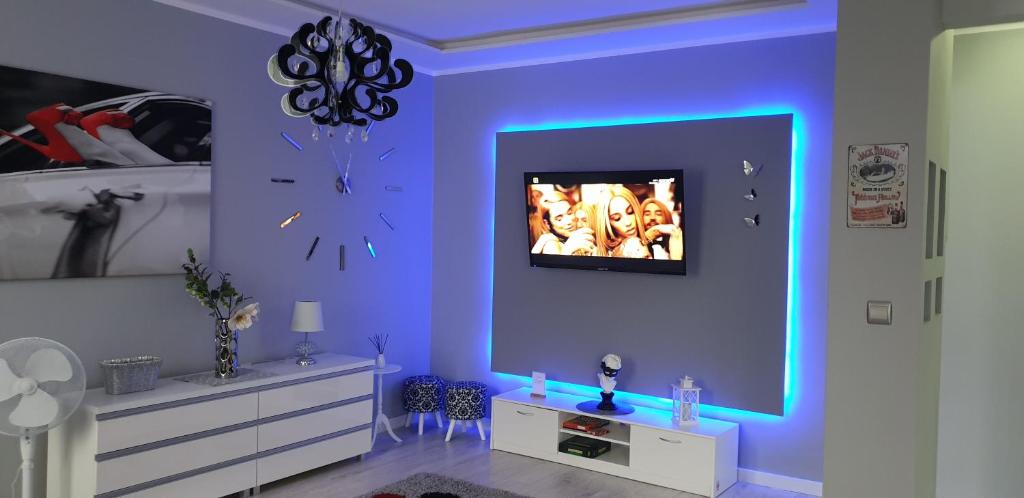 Pokój z fioletową ścianą z telewizorem w obiekcie Apartament Deluxe 3/10 w Zielonej Górze