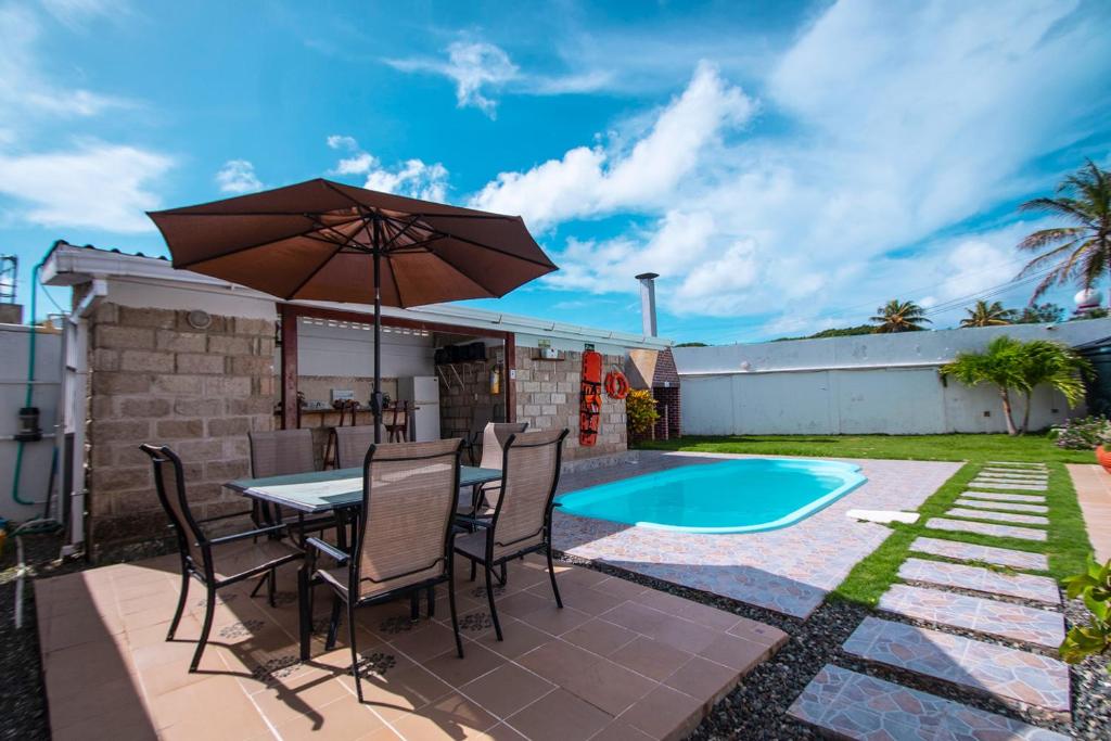 a patio with a table and chairs and an umbrella at Casa Boutique Blessed Place in San Andrés
