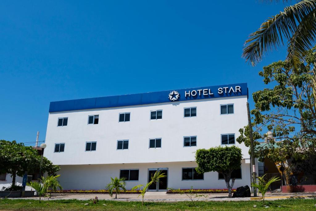 a white building with a hotel sign on it at Hotel Star in Manzanillo