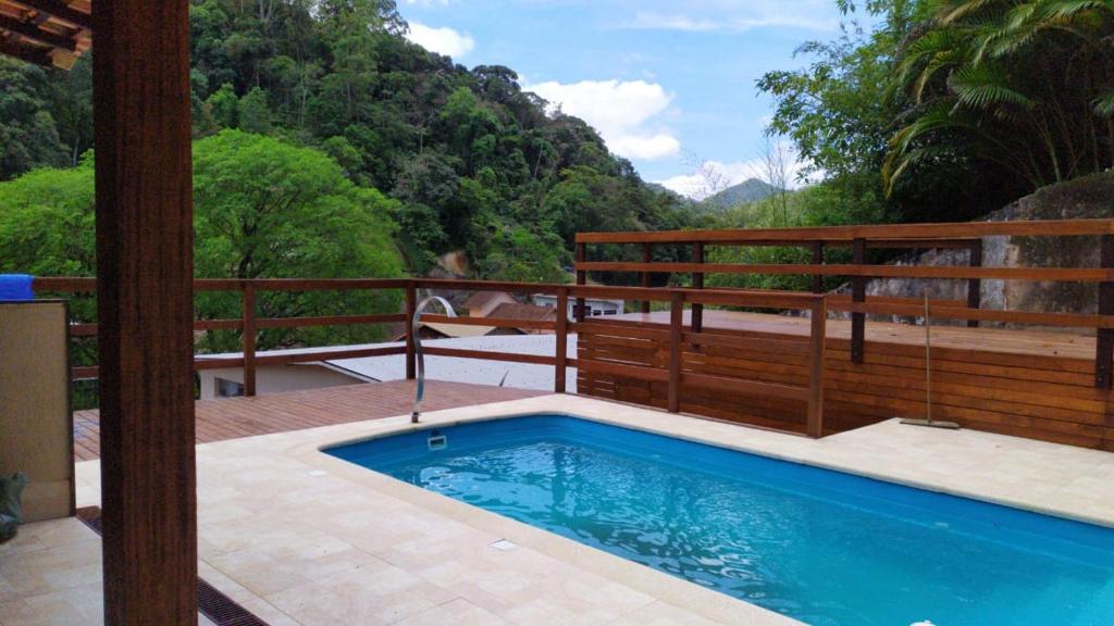 a swimming pool on a patio with a wooden fence at HOSTEL DU SUCA in Petrópolis