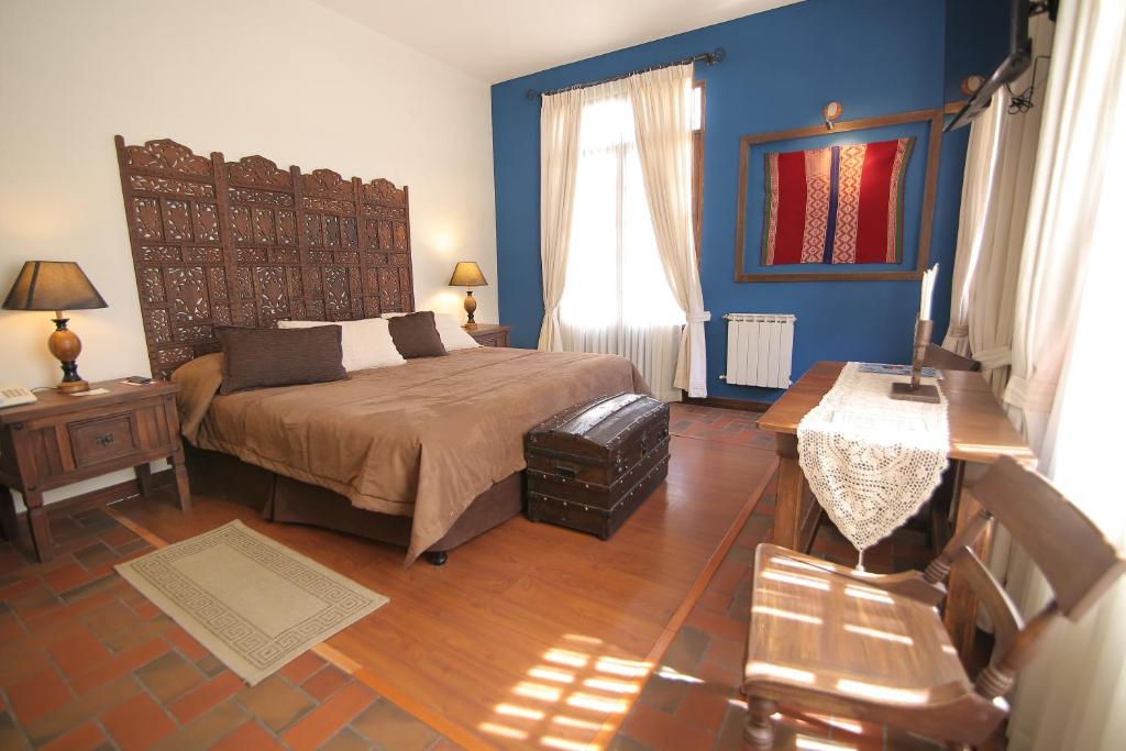 
a bedroom with a bed and a dresser at Mi Pueblo Samary Hotel Boutique in Sucre
