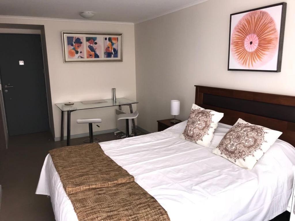 une chambre avec un lit et un bureau dans l'établissement Nuevo departamento Moneda, à Santiago