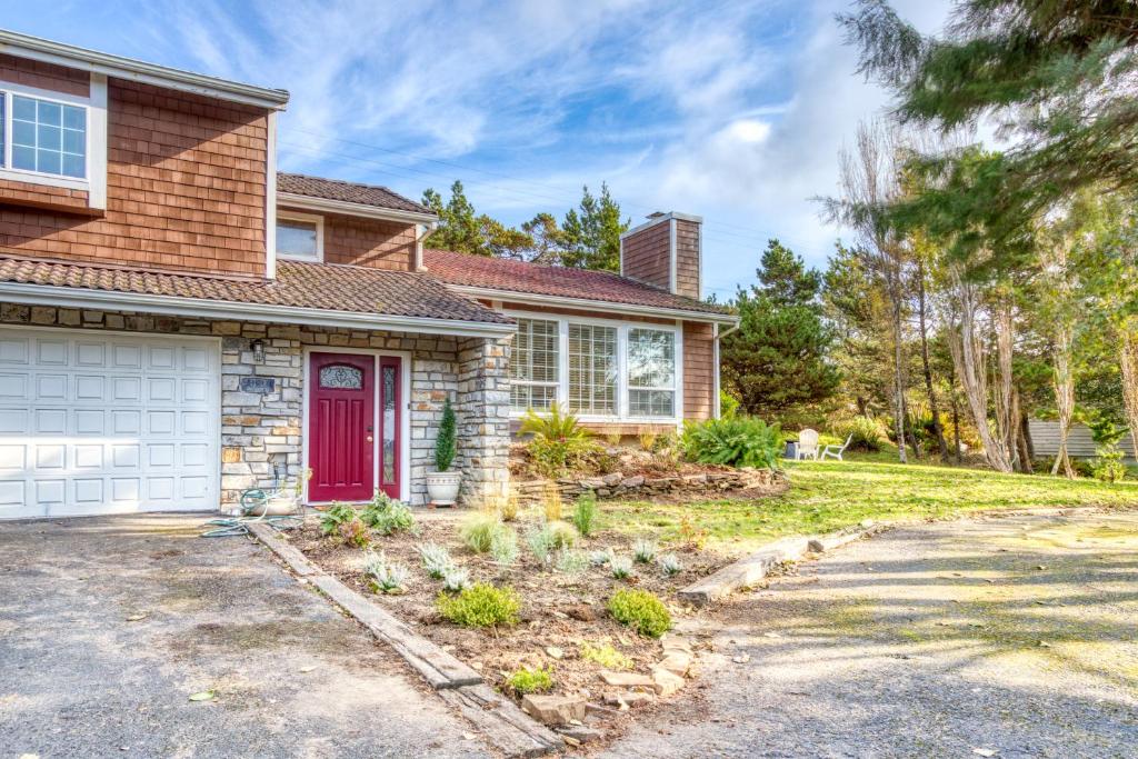 une maison avec une porte rouge et une cour dans l'établissement Seabreeze Getaway, à Warrenton