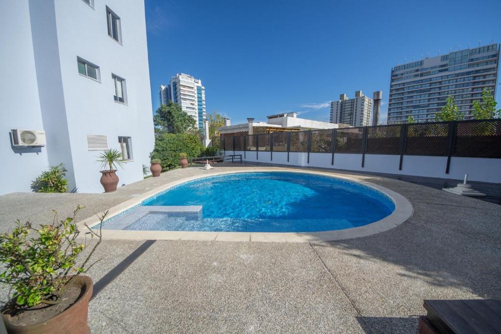 una piscina al lado de un edificio en Apartamento edificio Cap Ferrat en la mansa Punta del Este, en Punta del Este