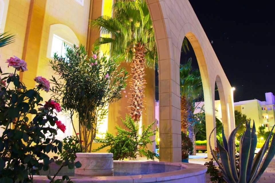 un edificio con una fuente con plantas delante en Апартаменты в комплексе Caesar Resort & Spa, en Trikomo