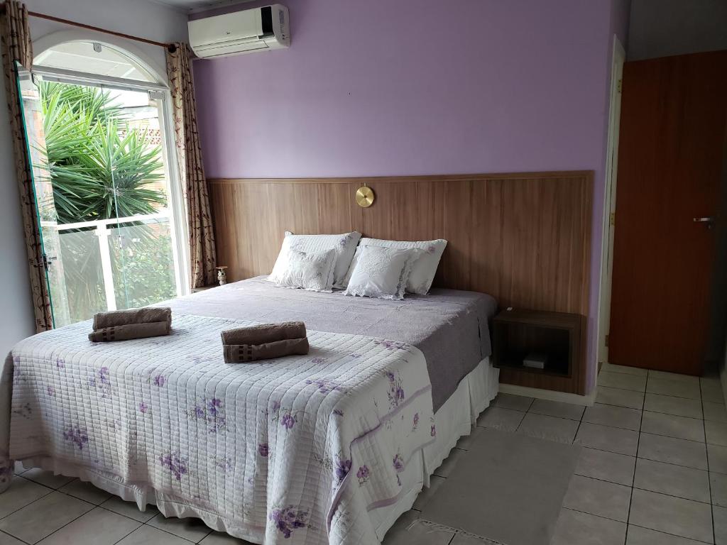 a bedroom with a large bed with two towels on it at Hostel Equilíbrio in Florianópolis