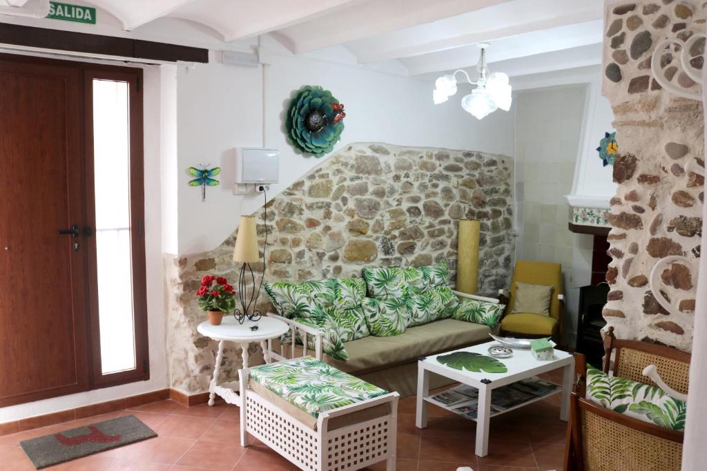 ein Wohnzimmer mit einer Couch und einer Steinwand in der Unterkunft Charming house in Estivella near nature in Estivella