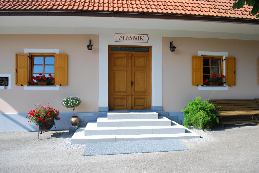 een gebouw met een trap naar een houten deur bij Farm Stay Rotovnik - Plesnik in Slovenj Gradec