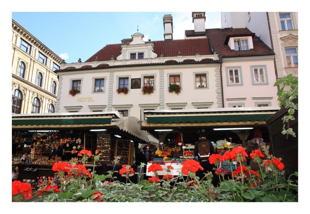 un mercado con flores rojas frente a un edificio en Prague Golden Age, en Praga
