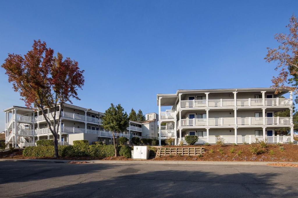 un gran edificio de apartamentos con árboles delante de él en SureStay Hotel by Best Western Fairfield Napa Valley, en Fairfield