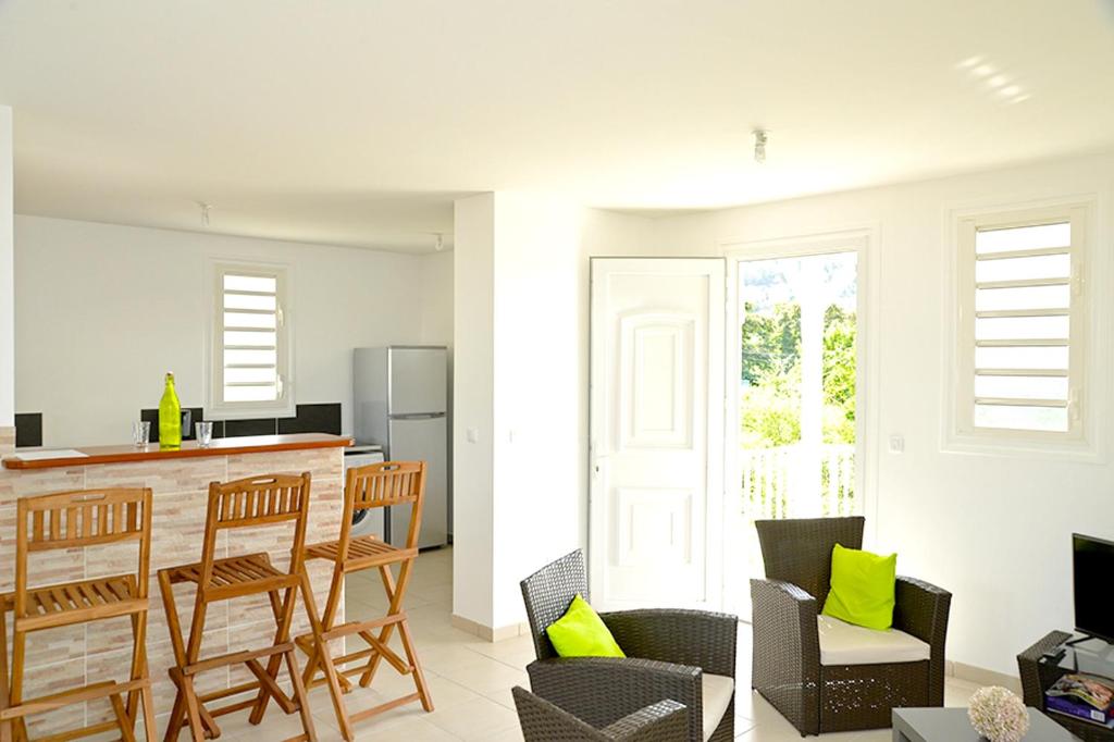 a kitchen and living room with a bar and chairs at Appartement de 2 chambres a Les Trois Ilets a 200 m de la plage avec jardin clos et wifi in Les Trois-Îlets