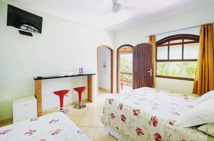 a bedroom with two beds and a television in it at Pousada Caruaru in Socorro