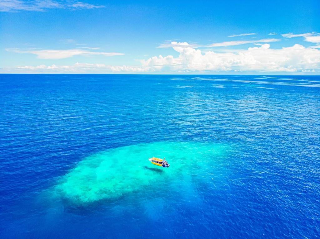 un barco flotando en medio del océano en Tufi Resort, en Tufi