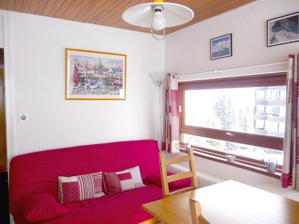 シャンルッスにあるAppartement d'une chambre avec balcon amenage a Chamrousseのリビングルーム(赤いソファ、窓付)