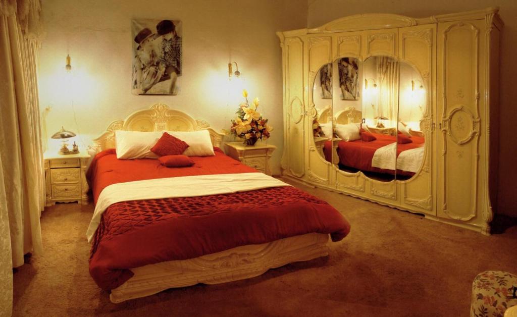 ein Schlafzimmer mit einem großen Bett und zwei Spiegeln in der Unterkunft Friends Hostel.Area B in Hebron